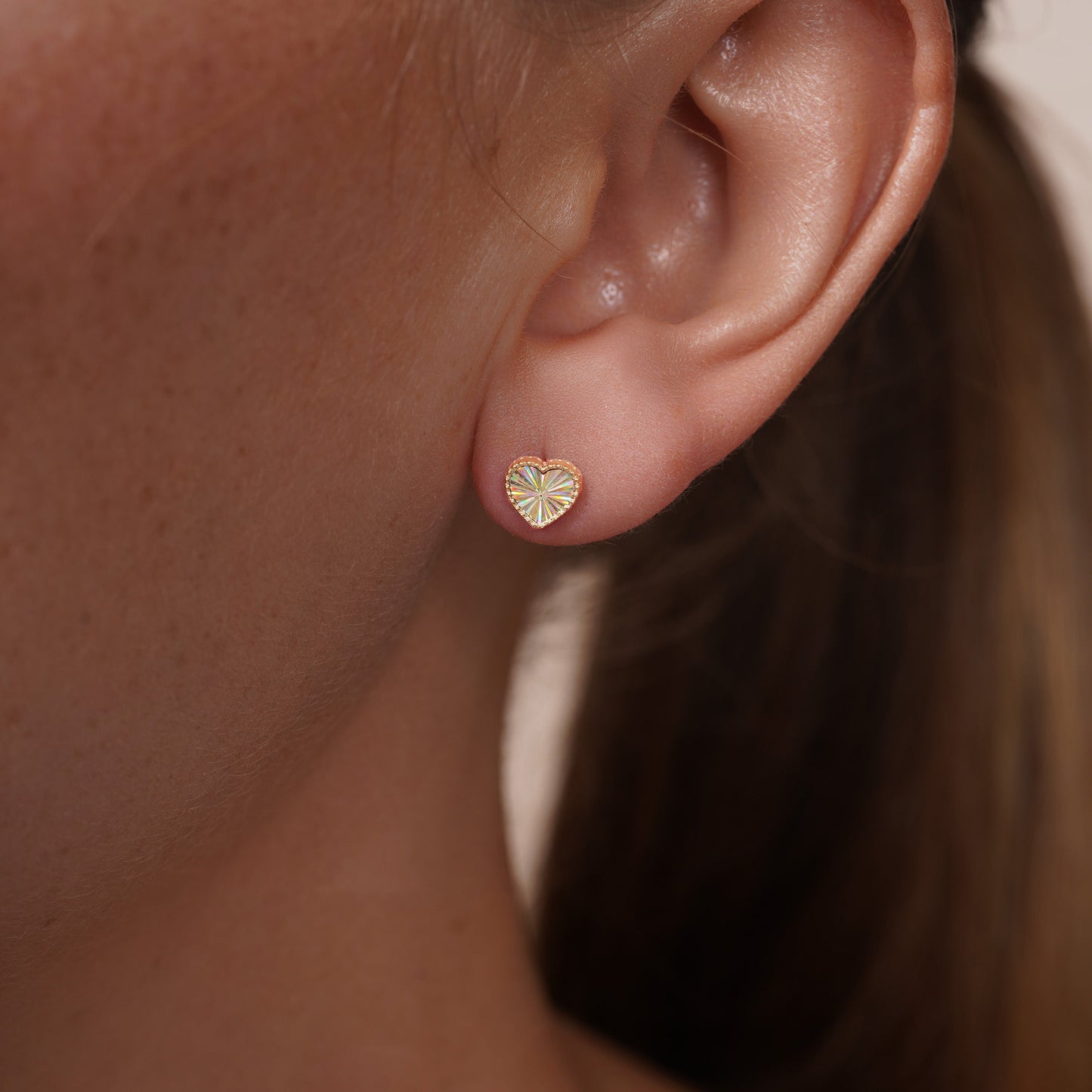 Beaded iridescent heart stud earrings in 14 karat gold, detail view