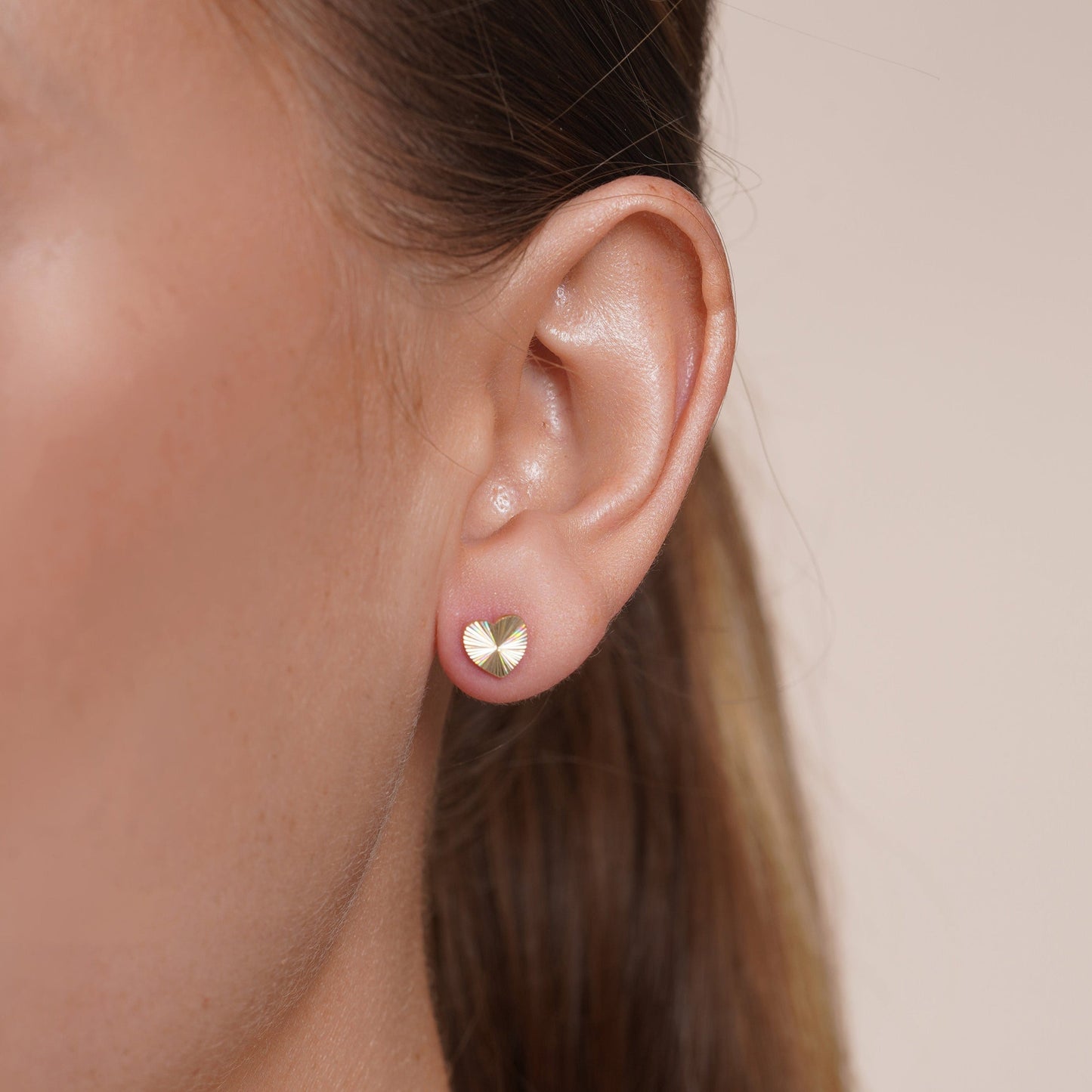Diamond-cut iridescent heart stud earrings in 14 karat gold, detail view