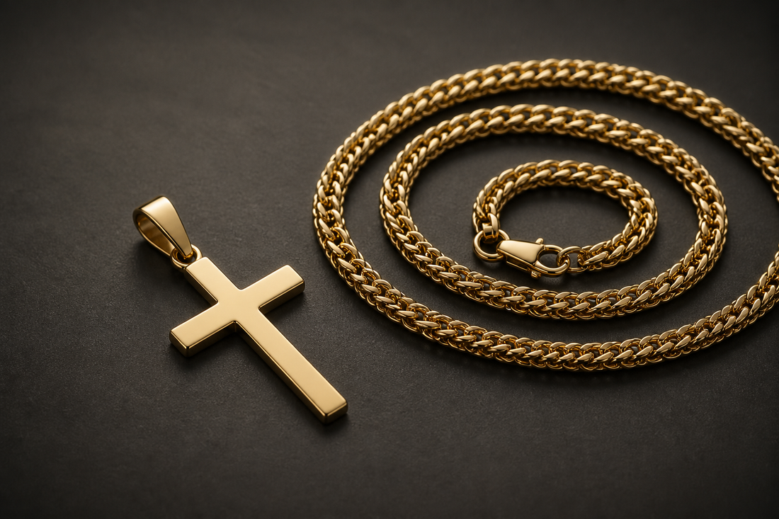 A gold cross pendant beside a coiled gold franco chain on a dark background