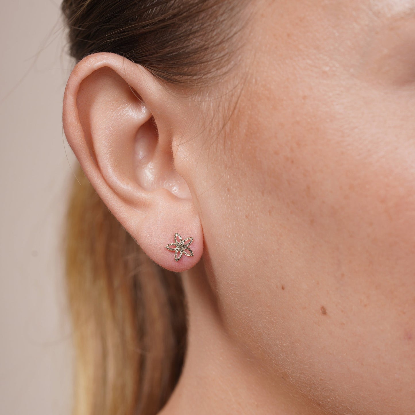 Diamond-cut star flower stud earrings in 14 karat gold, detail view
