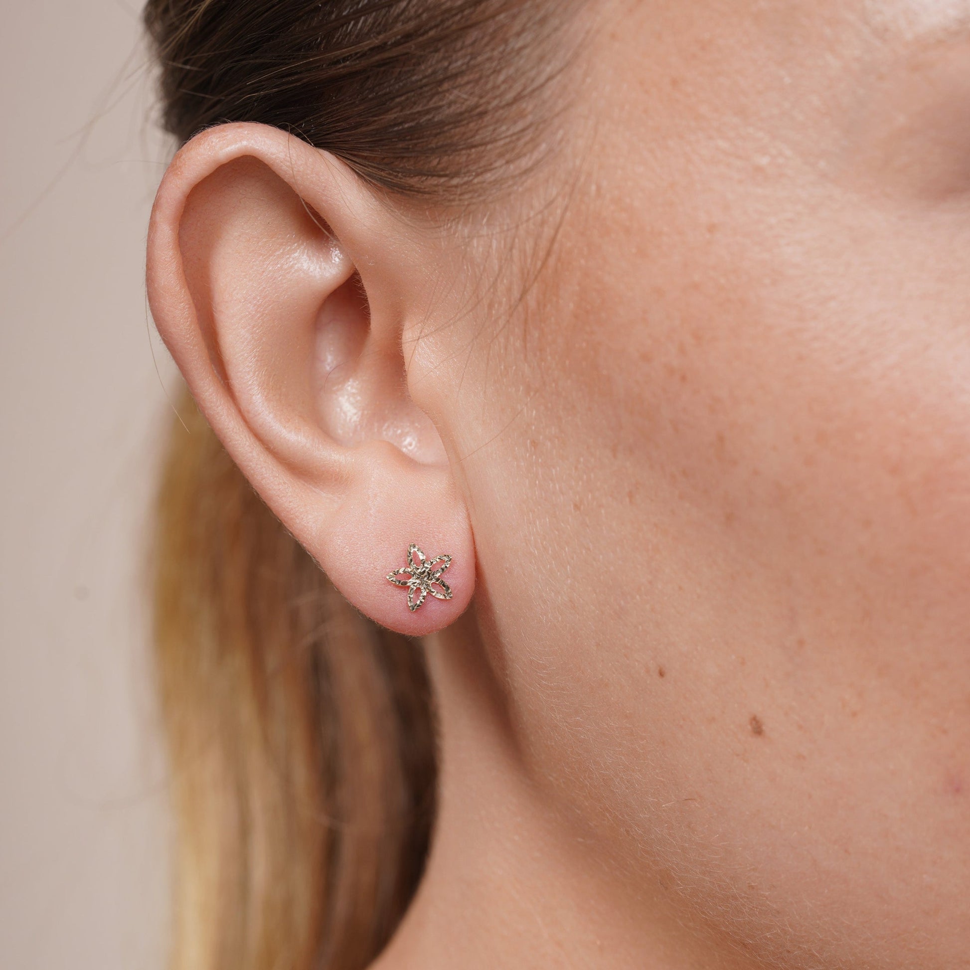 Diamond-cut star flower stud earrings in 14 karat gold, detail view