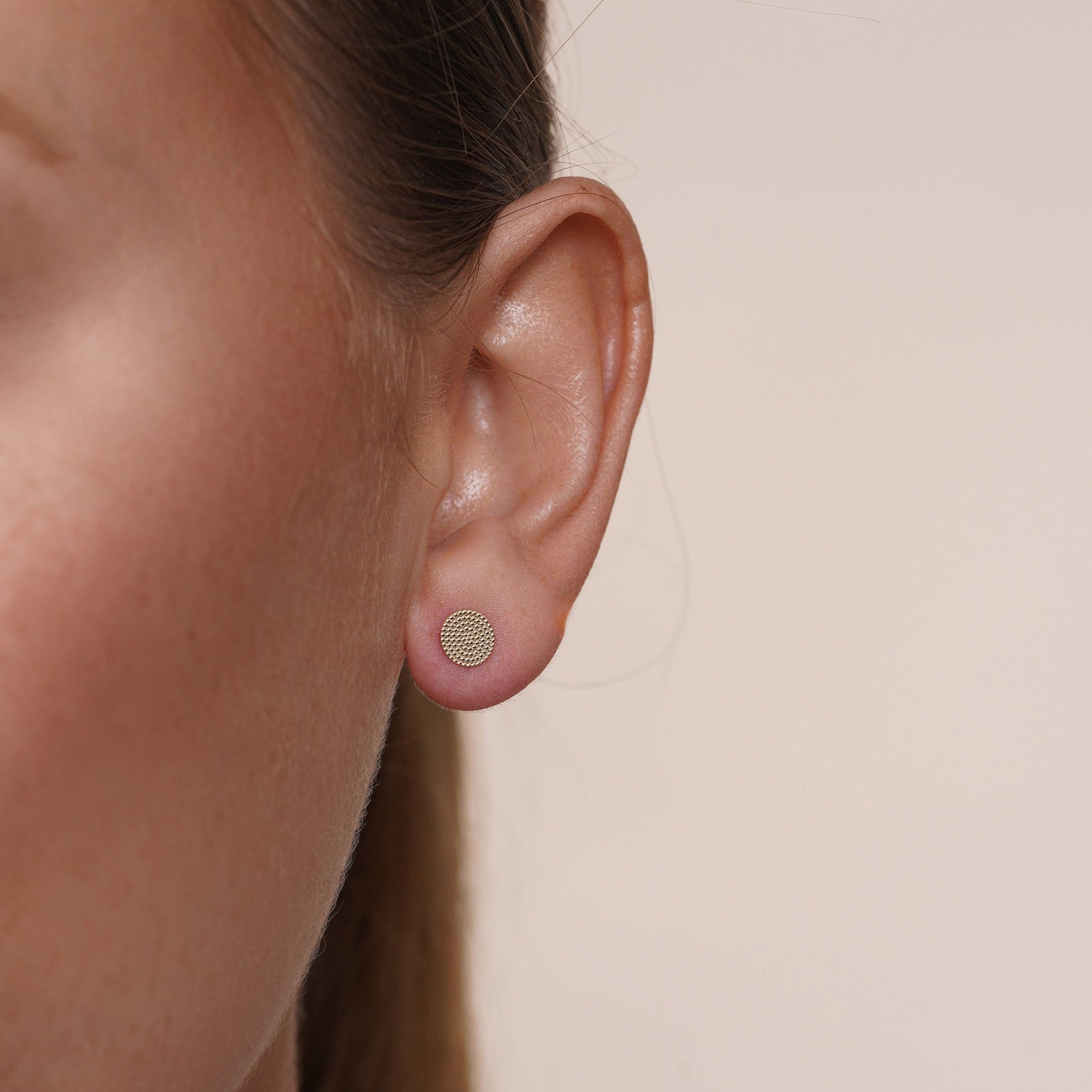 Beaded disc stud earrings in 14 karat yellow gold, detail view