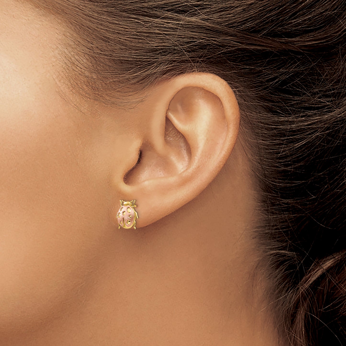 14K yellow and rose gold ladybug stud earring worn on the ear