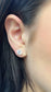 Pair of 14K yellow gold round moissanite studs on display