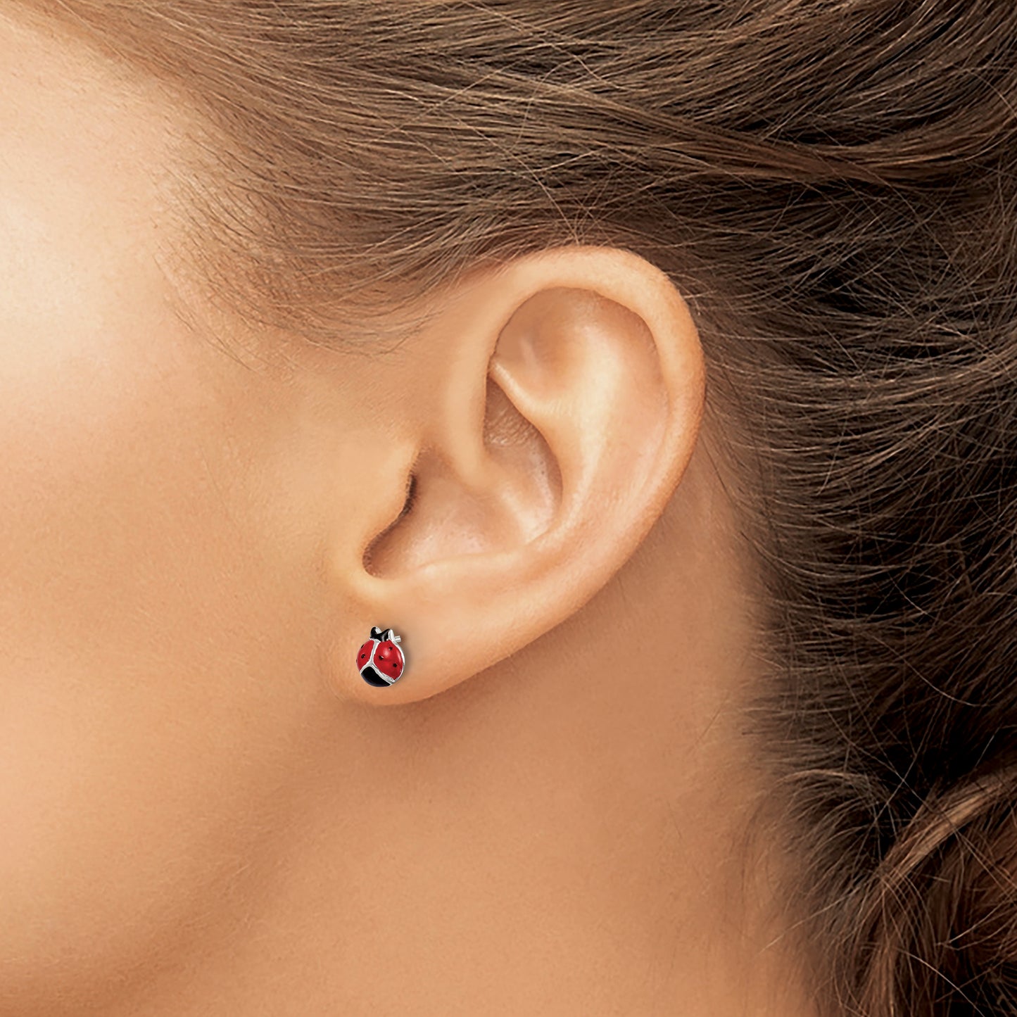 Sterling silver ladybug stud earring worn on the ear