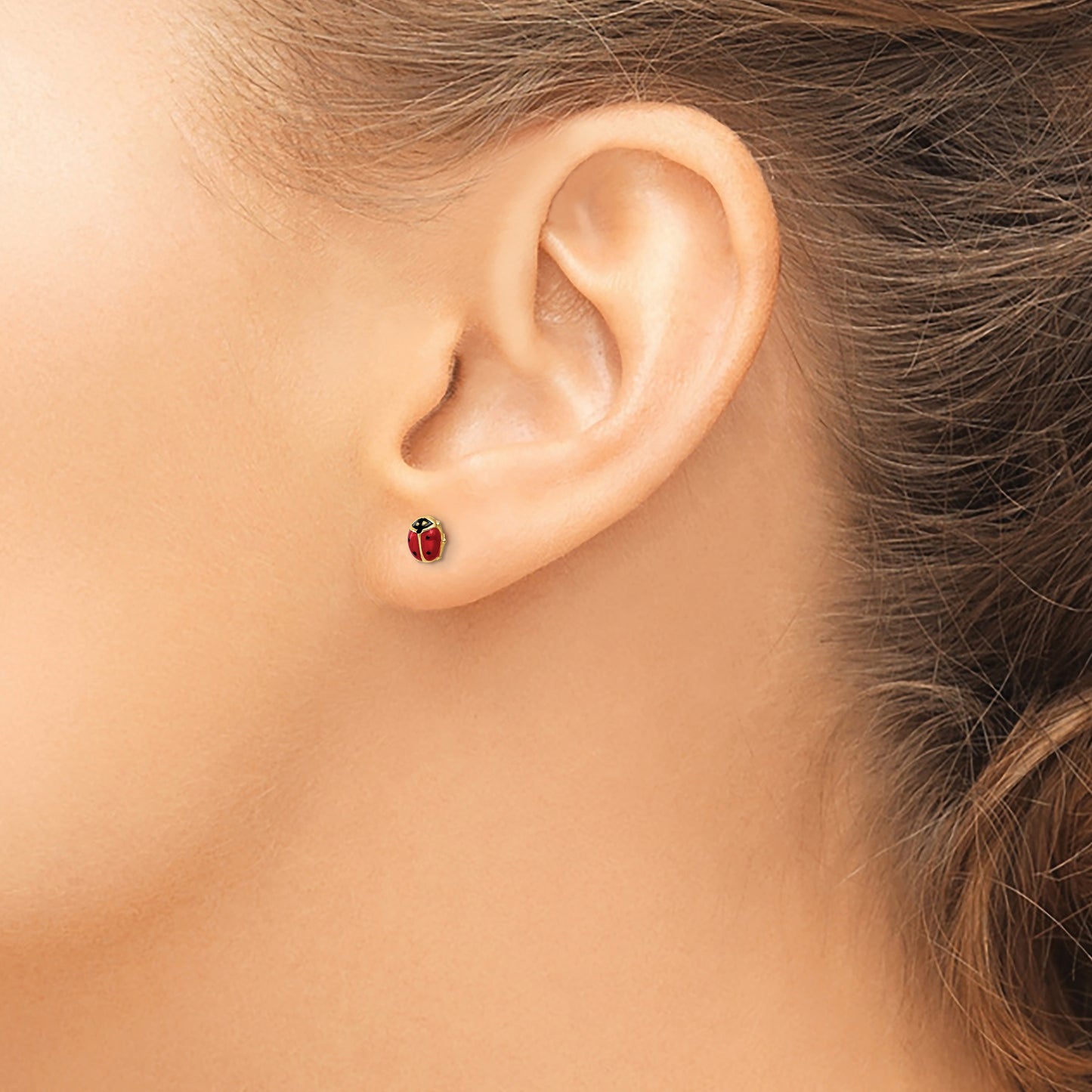 14K gold enamel ladybug stud earring worn on the ear